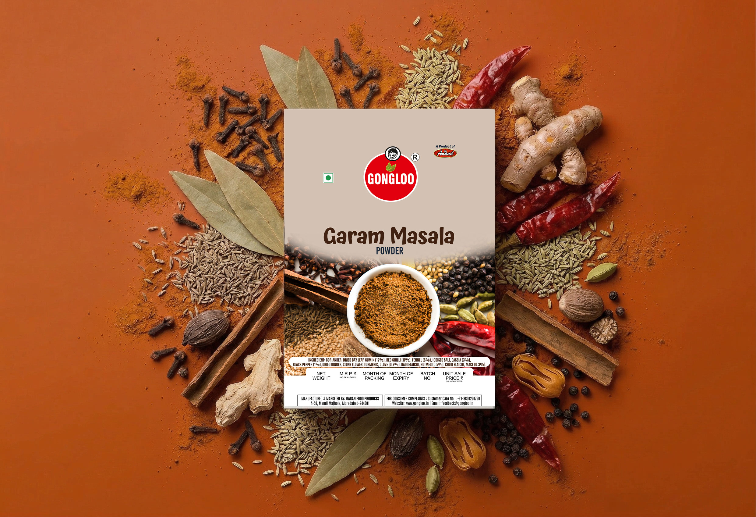 A garam masala spice pack surrounded by the whole spices in the blend: cloves, bay leaves, cinnamon, cardamom, chillies and ginger